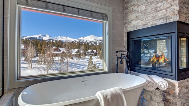 A bathroom with a large window, a bathtub, and a fireplace. - Creekside Escape: Breck Home, Hot Tub & Steam Shower, Walk to Shuttle! (Breckenridge)