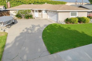 A single-story house with a garage, a driveway, and a well-maintained lawn. - Beautiful Modern Clean Family 1 Story Home! Near Disneyland, Chapman Convention (Orange)