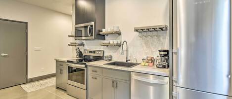A modern kitchen with stainless steel appliances, a dishwasher, and a built-in oven.