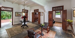 A spacious foyer with a chandelier, wooden doors, and a large rug. - Nyne Hotels Leela Walauwwa - Induruwa (Induruwa)