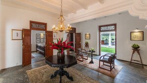 A spacious foyer with a dark wooden table, a chandelier, and a large rug. - Nyne Hotels Leela Walauwwa - Induruwa (Induruwa)