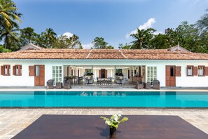 A hotel with a swimming pool, outdoor seating area, and a covered patio. - Nyne Hotels Leela Walauwwa - Induruwa (Induruwa)