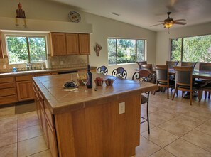 Una cocina amplia con una isla grande, armarios de madera y una zona de comedor con sillas y una mesa.