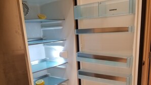 Un réfrigérateur ouvert, doté de plusieurs étagères et d’un distributeur d’eau.