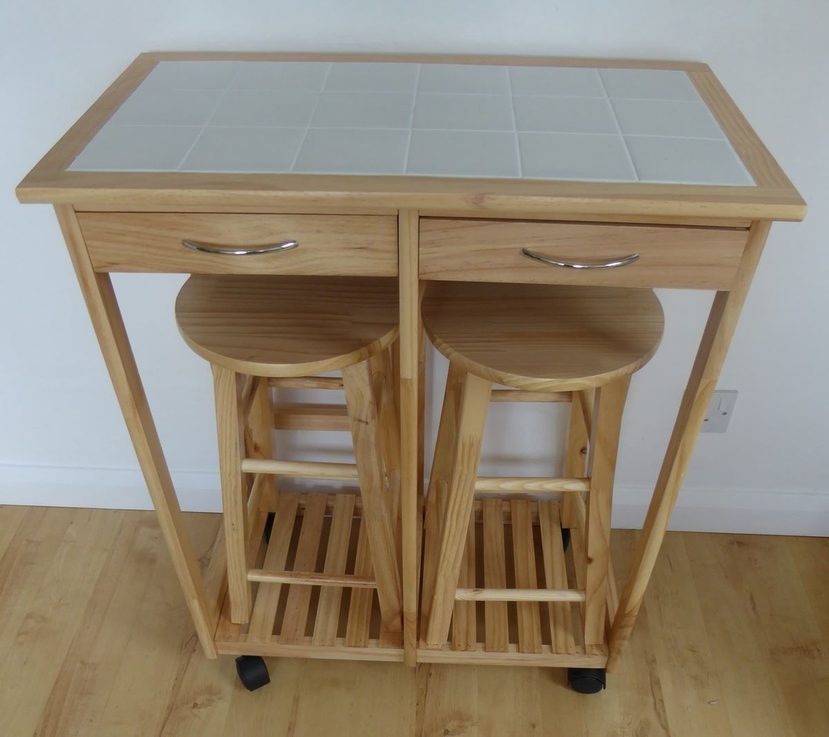 A wooden desk with two drawers and a shelf, featuring a tiled top.