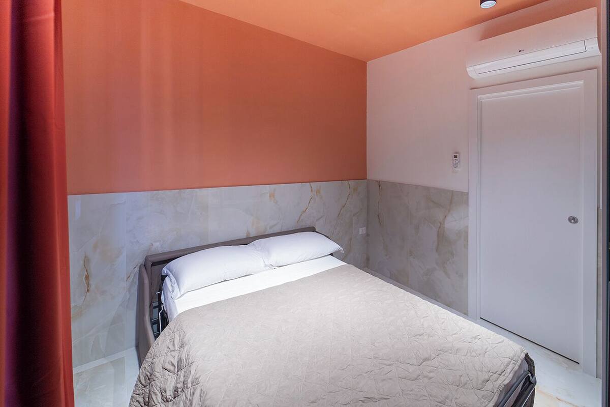 Une chambre à coucher avec un lit, une armoire et une porte.