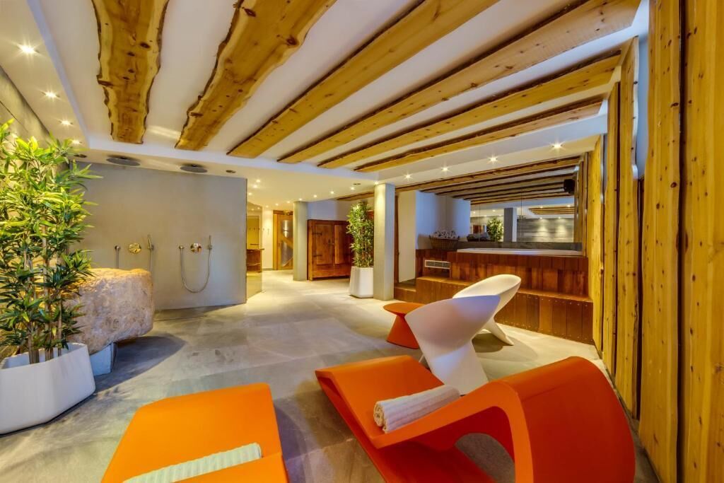 Un intérieur moderne avec des poutres en bois, un espace d’accueil et des sièges avec des serviettes à disposition.