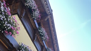 A building with multiple balconies adorned with flower boxes. - Hotel Oberdorfer Stuben (Obermaiselstein)