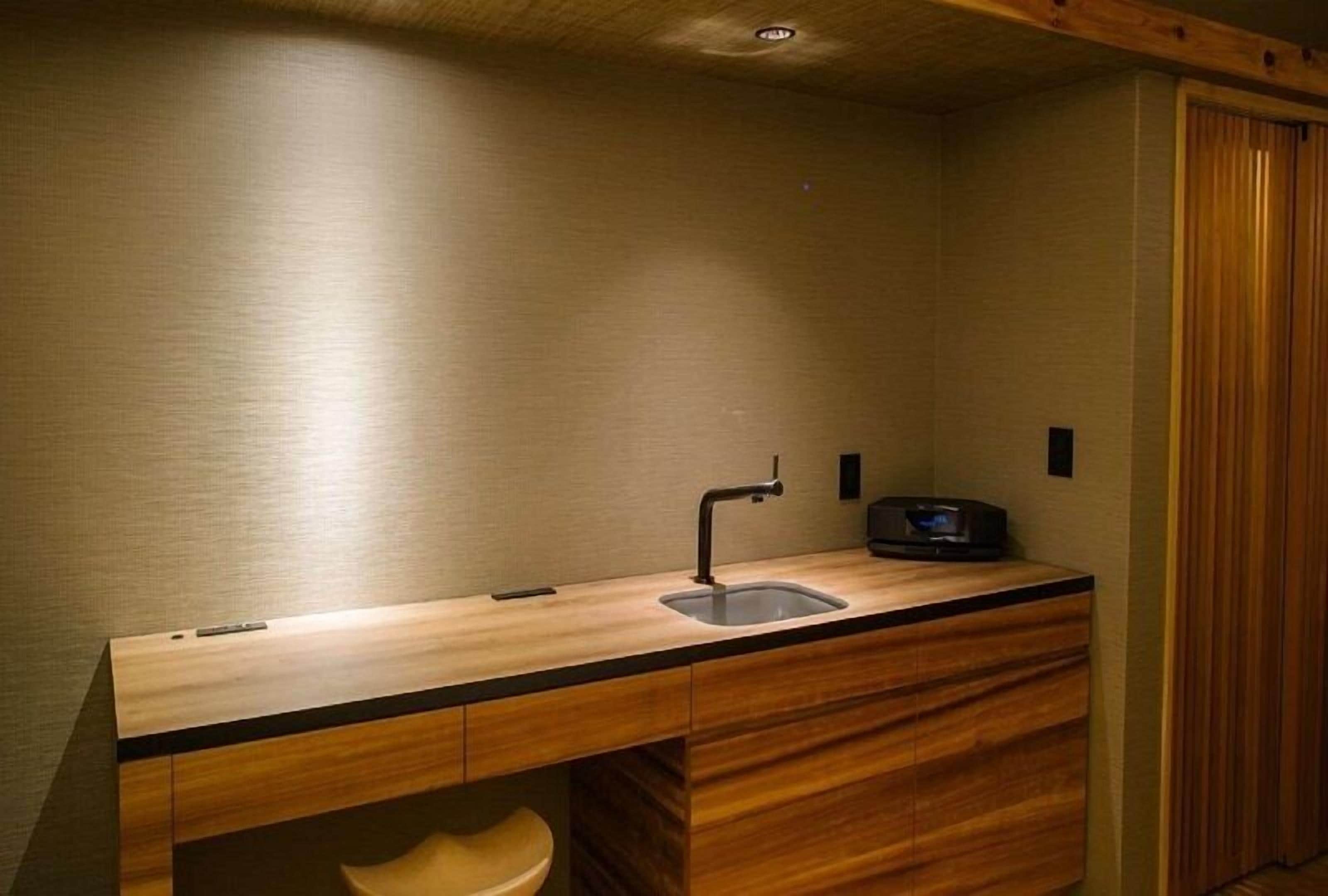 A compact bathroom with a wooden vanity, a sink, and a toilet.