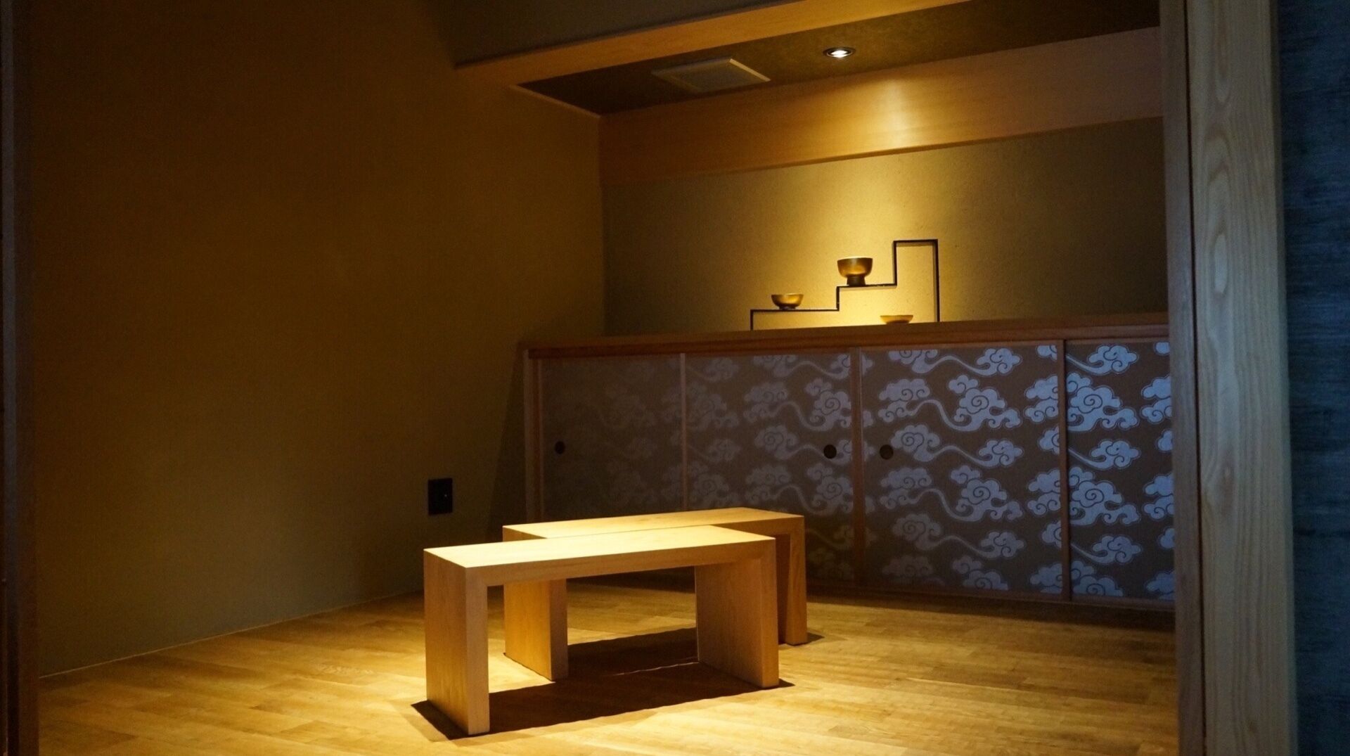 A room with a wooden bench, a low table, and a patterned cabinet.