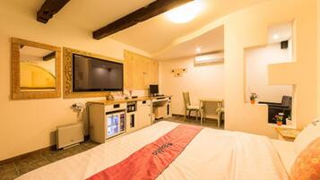 Una habitación de hotel con una cama, televisión, escritorio y una silla.