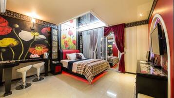 A bedroom with a bed, a desk, a chair, and a mirror.