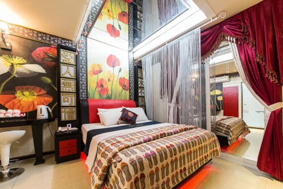 Une chambre à coucher avec un grand lit, un bureau et une tête de lit rouge.