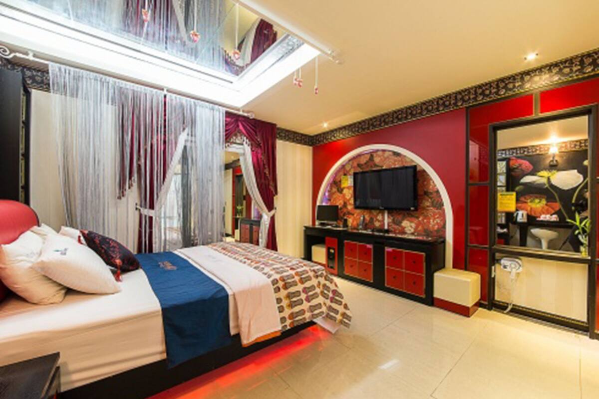 Une chambre d’hôtel avec un lit, une télévision, une coiffeuse et un balcon.