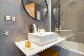 Een bad/douchecombinatie, een haardroger, handdoeken