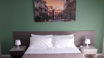 A hotel room with a bed, two bedside tables, and a painting of a cityscape on the wall.