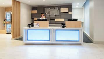 Een hotel receptiebalie met een modern ontwerp, voorzien van een computer en een telefoon.