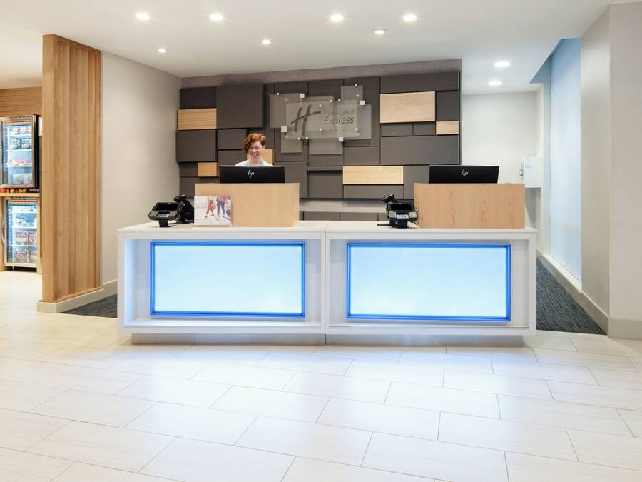 Un mostrador de recepción de hotel con un diseño moderno, equipado con una computadora y un teléfono.