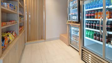 Uma área com lanches e bebidas, com prateleiras repletas de diversas opções.