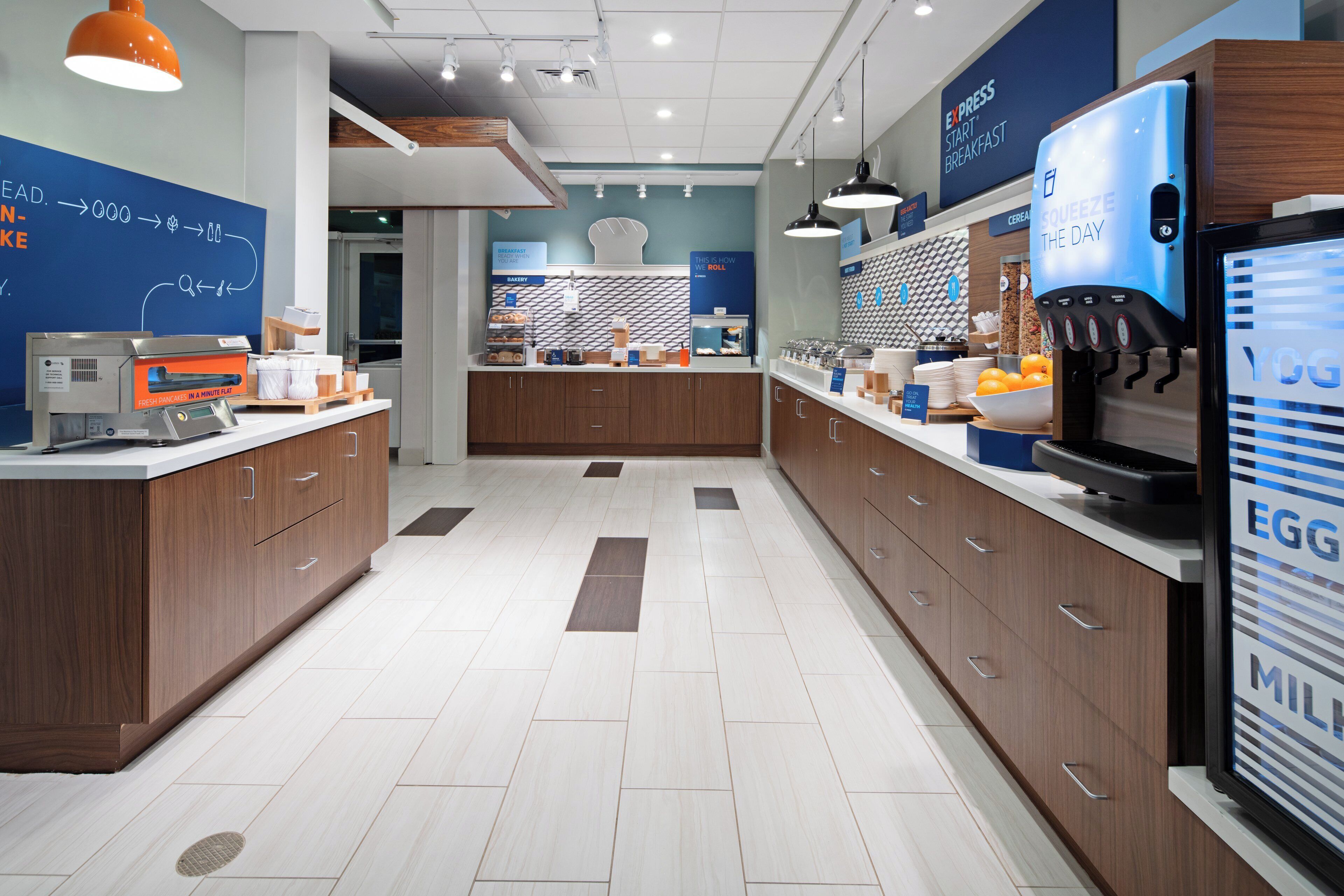A modern kitchen with a breakfast bar, a coffee machine, and a yogurt dispenser.