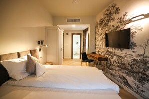 Minibar, escritorio, cortinas blackout y tabla de planchar con plancha