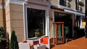 An outdoor seating area with wicker furniture and potted plants. - Pensiunea Nora (Timisoara)