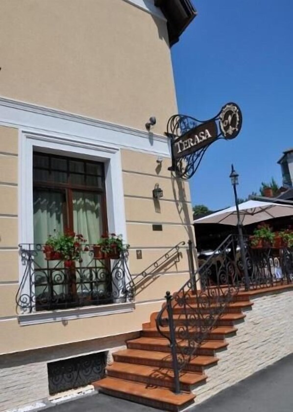 Un edificio con un letrero que dice "TERASA" y una escalera que conduce a la entrada.