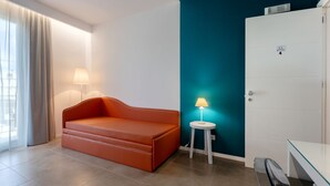 A modern room with a sofa, a lamp, a wardrobe, and a glass table. - Sirius (San Vito Lo Capo)