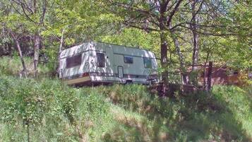 A recreational vehicle parked in a wooded area.