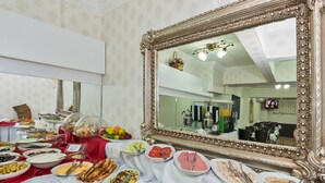 A buffet table with various food items and a large ornate mirror. - Le Safran Palace (Istanbul)