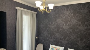 A bedroom with a bed, two pillows, a chair, a window with curtains, and a chandelier. - Your House in Tbilisi (Tbilisi)