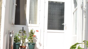 A white door with a window above it, a brick staircase leading up to the door, and potted plants on the steps. - Your House in Tbilisi (Tbilisi)