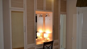 A bedroom with a wooden wardrobe, a bedside table with a lamp, and a mirror. - Your House in Tbilisi (Tbilisi)