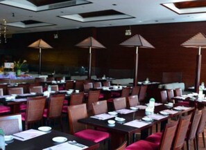 Un restaurant doté de nombreuses tables et chaises, chacune étant mise avec des assiettes, des couverts et des serviettes.