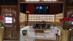 A traditional tea house with a wooden facade, a seating area with tables and chairs, and a display of tea sets. - Shenzhen Kaijia Hotel (Shenzhen)