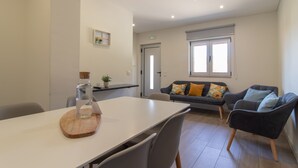 A modern living room with a dining table, a sofa, and a chair.