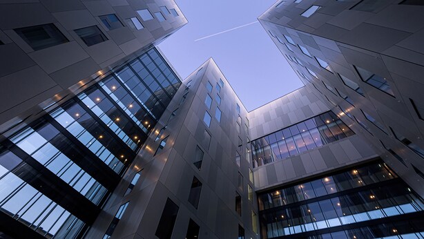 Un moderno edificio de gran altura con varios pisos y ventanas amplias.