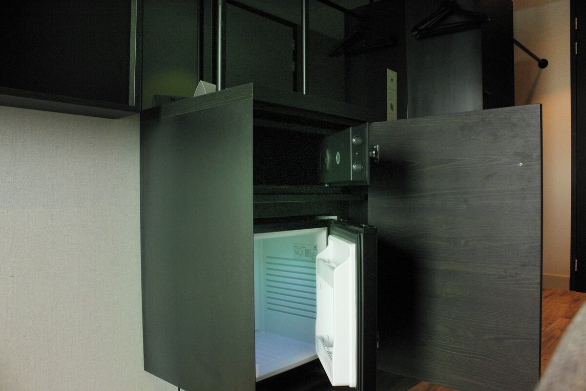A modern kitchen with a built-in refrigerator and a microwave.