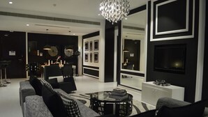 A modern living room with a sofa set, a coffee table, and a chandelier.