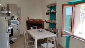 Une cuisine compacte comprenant un coin repas, un four à micro-ondes, une cuisinière et une fenêtre donnant sur un paysage agréable.