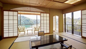 A traditional Japanese room with tatami flooring, a low table, and sliding doors. - Kumano-bettei Nakanoshima (Nachikatsuura)