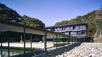 A modern building with multiple balconies overlooking a rocky waterfront.