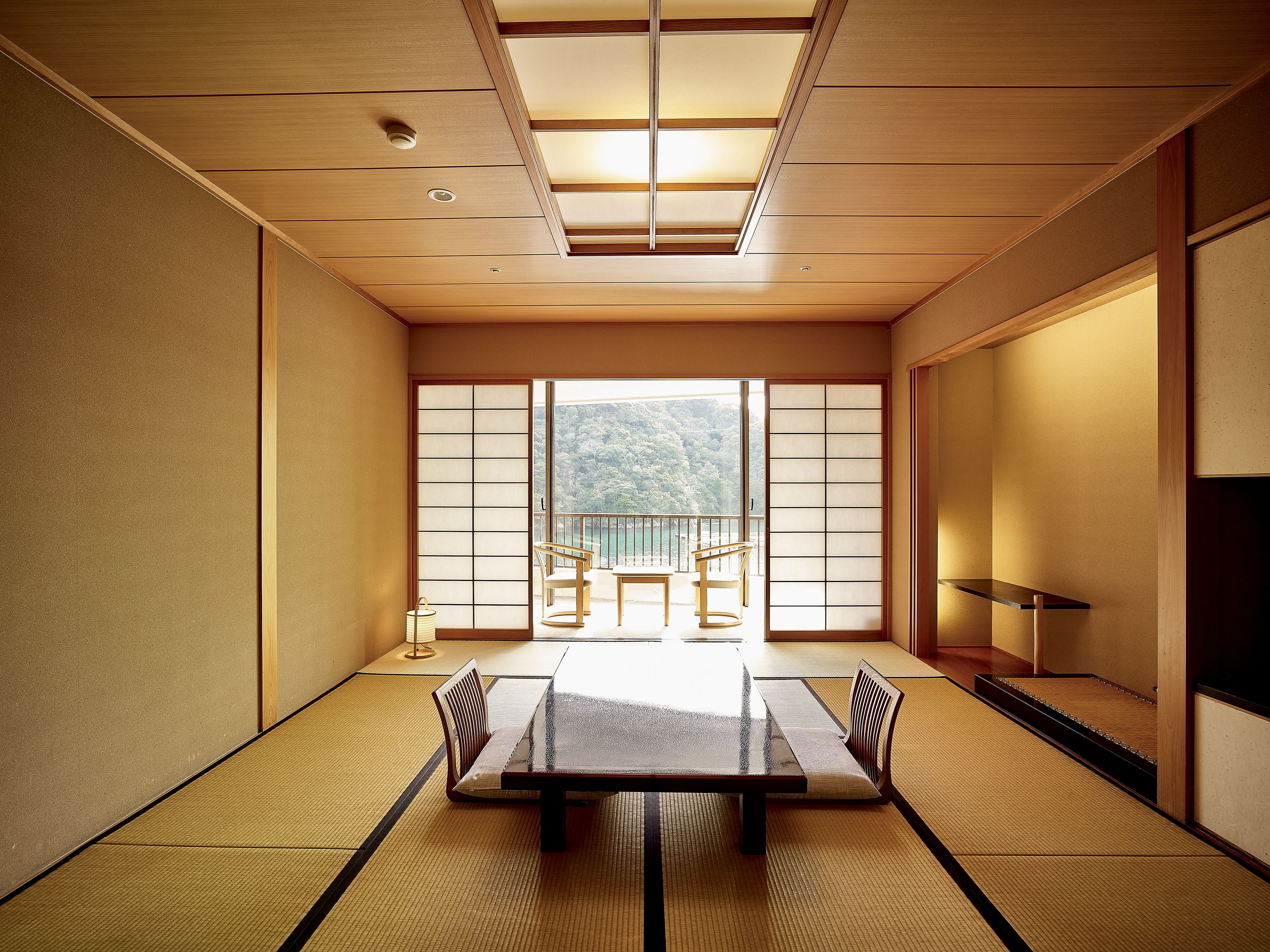 A traditional Japanese room with tatami flooring, a low table, and sliding doors.