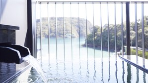 A water feature with a waterfall, a balcony railing, and a view of a natural landscape. - Kumano-bettei Nakanoshima (Nachikatsuura)