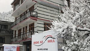 Ein mehrstöckiges Gebäude mit einem Schild, auf dem "Ride at Hill" und "Nihal Hotel & Cottage" steht.