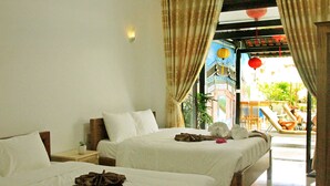 Habitación de hotel con dos camas, una mesita de noche y vistas a la zona de la piscina.