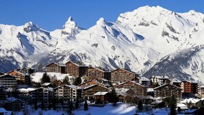 A snow-covered mountain resort with multiple wooden buildings, likely offering lodging and amenities for visitors. - Pracondu 1 002 - OUTDOOR & FUN  charming apartment (Haute-Nendaz)