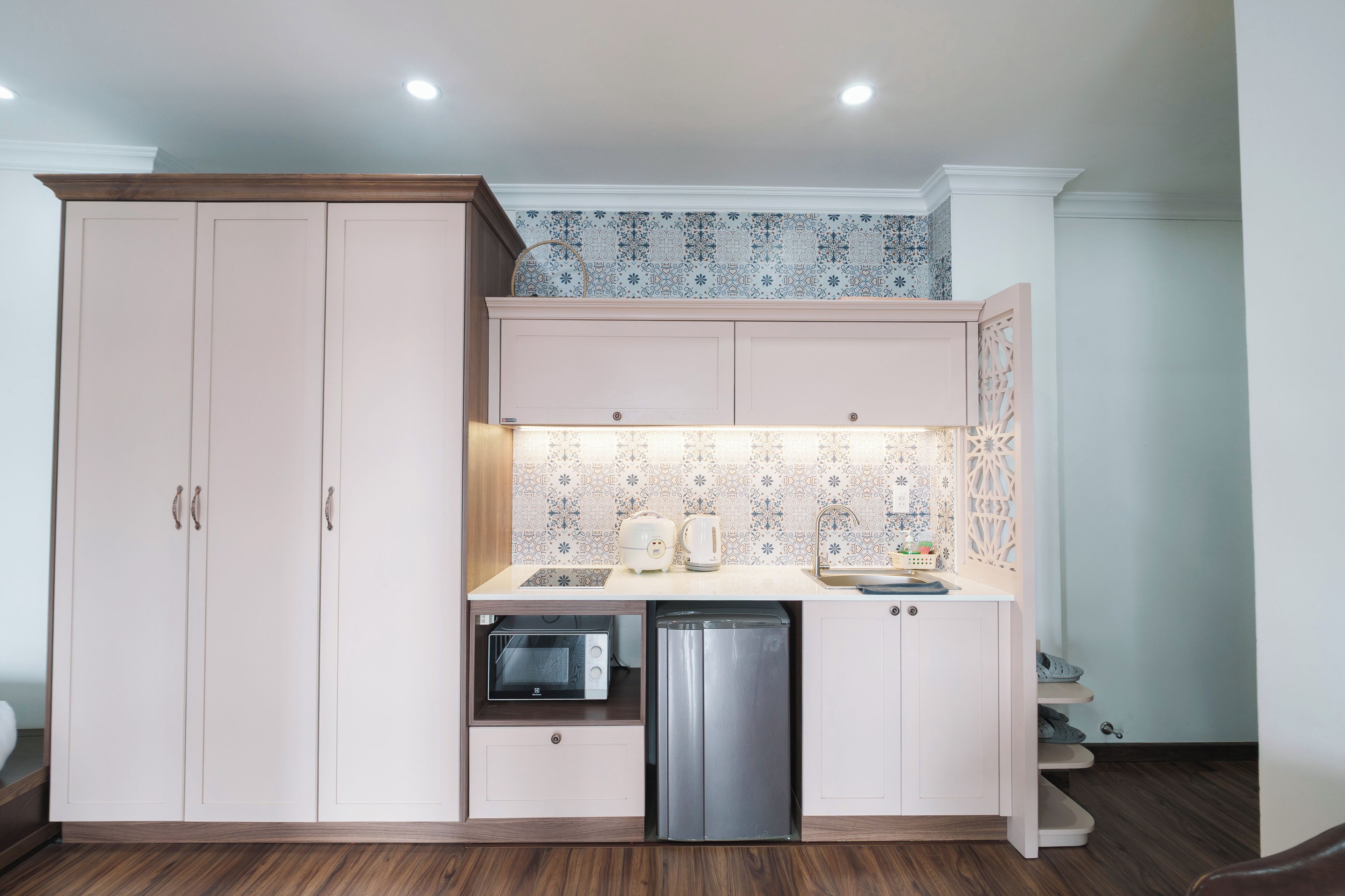 A compact kitchen with a microwave, toaster, and dishwasher built into the cabinetry.
