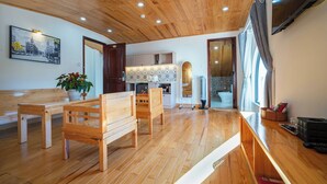 A modern kitchen with wooden cabinets, a built-in oven, and a large window. - N Queen Apartment Hotel (Xuan Huong - Da Lat)