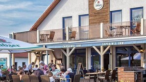 Captain's Inn con posti a sedere all'aperto e insegna con la scritta 'birra'.